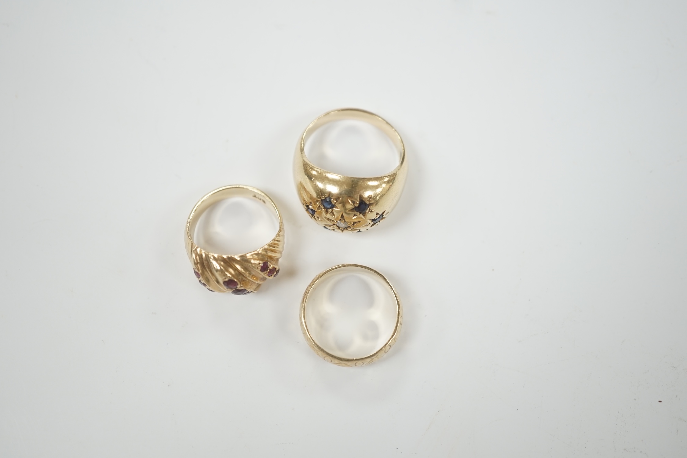 Two modern 9ct gold and gem set dress rings and a similar engraved 9ct gold band